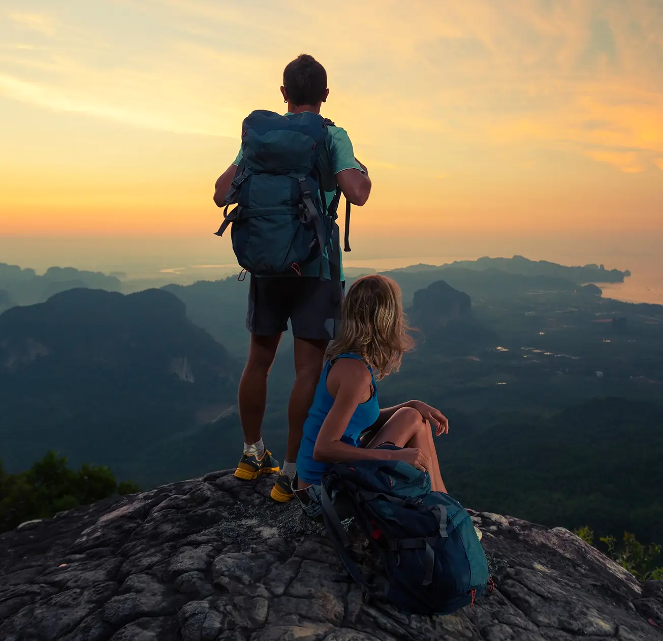 Couple de randonneurs au sommet d'une montagne avec une vue magnifique sur la mer