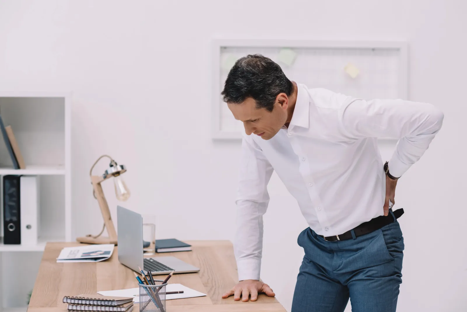 Homme ressentant une douleur au bas du dos dans un bureau